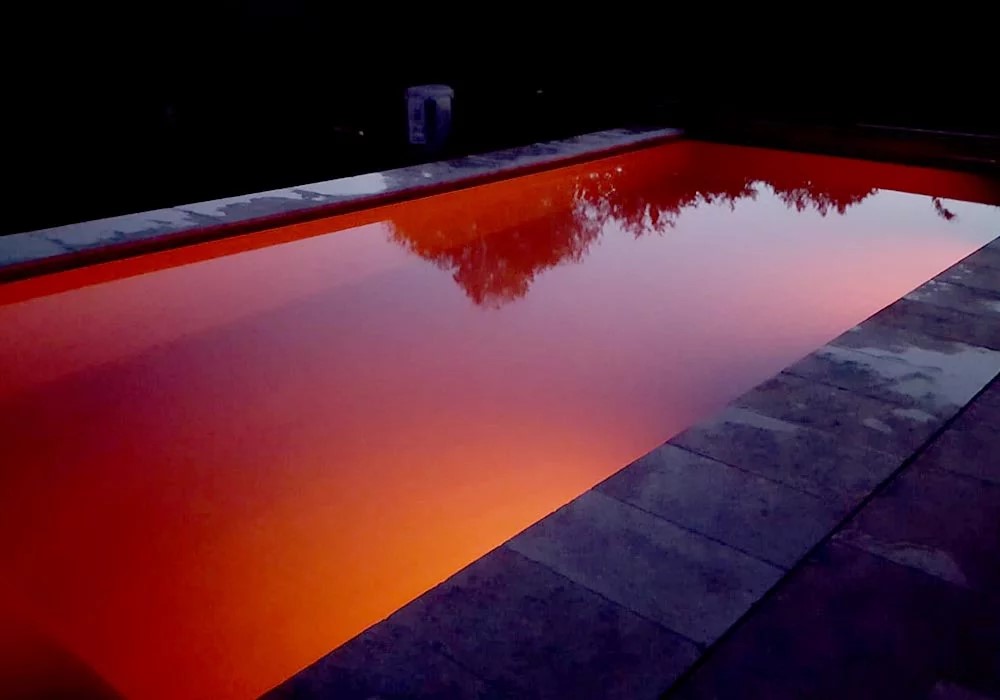 Detailansicht von einem Swimming Pool mit rot-oranger Beleuchtung