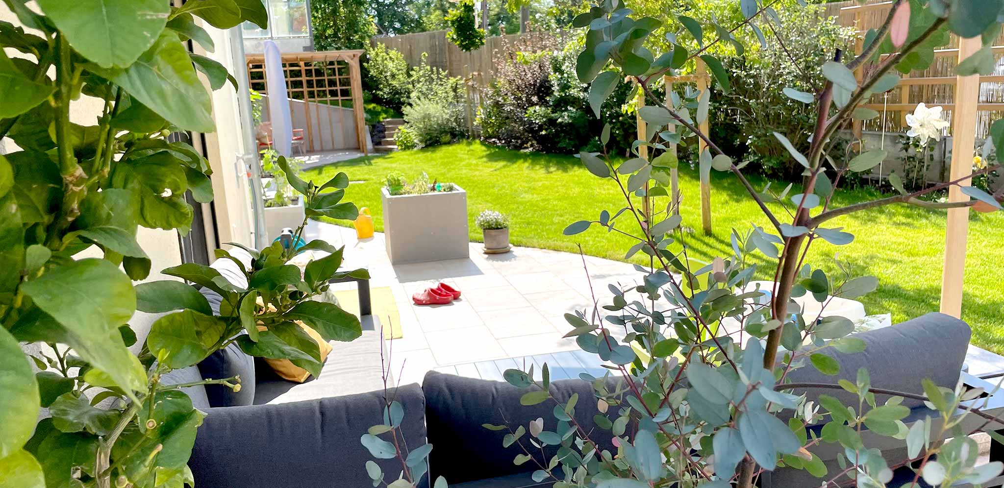 Ansicht auf einen gemütlichen Garten in Wien mit Terrasse und Loungmöbeln